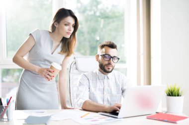 İki başarılı modern girişimci birlikte güneşli ofis masasında çalışan portresi