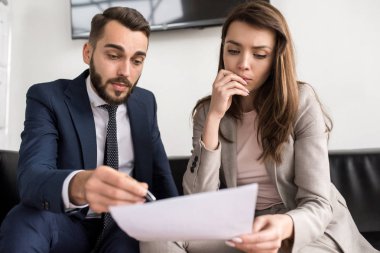 Önden görünüm portre iki modern iş adamları, erkek ve kadın office belgelerinde tartışıyor