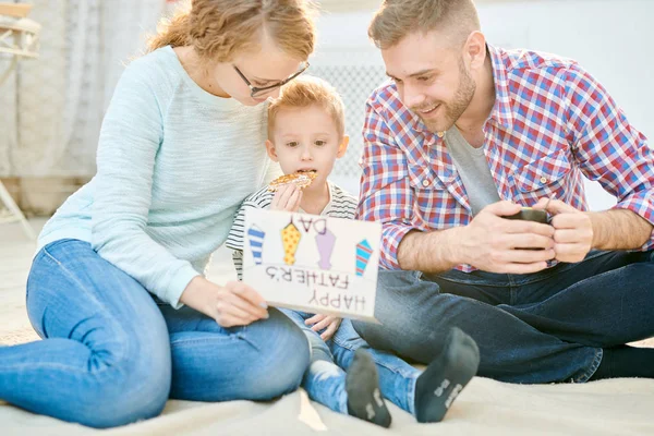 父の日を一緒に祝って居間の床の上に座って幸せな愛情のある家族の暖かいトーン肖像 — ストック写真
