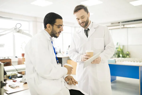 Positiver Gutaussehender Bärtiger Laborant Zeigt Konzentrierten Arabischen Kollegen Testgeräte Bericht — Stockfoto