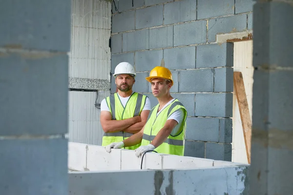 Retrato Dois Trabalhadores Construção Civil Vestindo Chapéus Duros Coletes Reflexivos — Fotografia de Stock