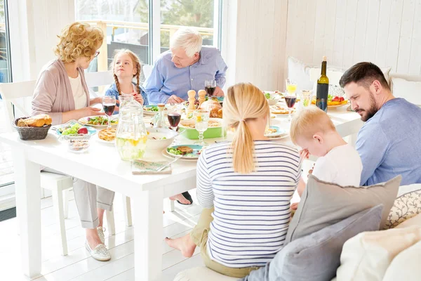 Portrait of big happy family enjoying dinner together sitting round festive table with delicious dishes, copy space