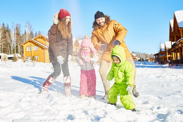 年轻的高加索夫妇和他们的孩子玩雪和微笑愉快地在美丽的冬下午出城 — 图库照片