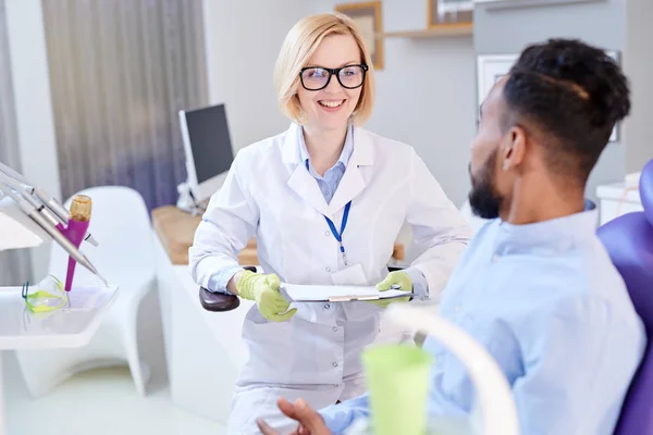 Smiling Pretty Stomatologist Wearing Rubber Gloves White Coat Holding Clipboard — Stock Photo, Image