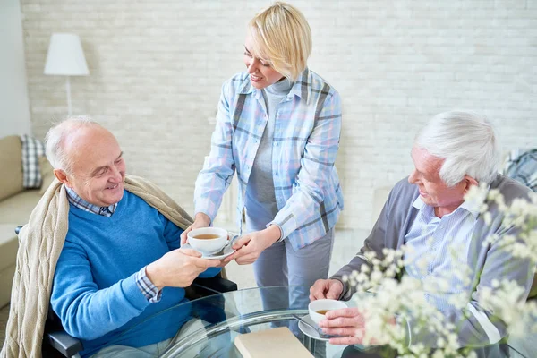 Portrait Blonde Young Woman Serving Tea Senior People Smiling Happily — Stock Photo, Image
