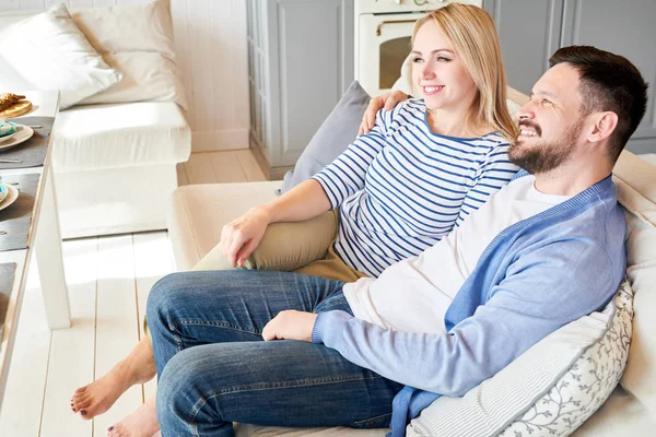现代年轻夫妇的肖像放松在舒适的白色沙发上客厅和微笑愉快地享受休闲时间在家里 复制空间 — 图库照片