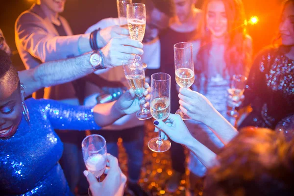在多民族群体中 欢笑的年轻人在夜总会享受舞会 喝香槟 专注于碰杯 — 图库照片