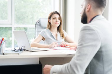 Büyük ofis masasında oturan ve istemciye konuşmak güzel işkadını portresi