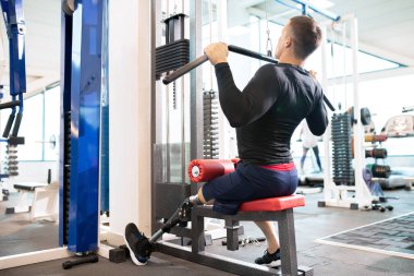 Tam uzunlukta bir protez bacak modern spor salonunda makinasıyla dışarı çalışma ile yakışıklı kaslı adam arkadan görünüm