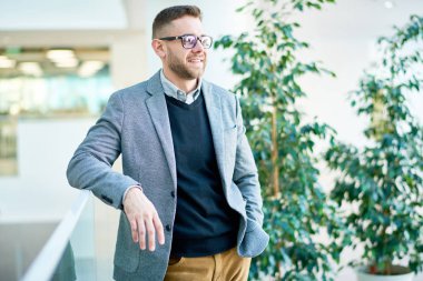 Gülümseyen portre çekim gözlük uzak duran geniş ofis lobisinde, arka plan bulanık seyir Manager'da sakallı