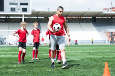 Genç erkek grup öğretim sırasında tarlada yürüyüş yakışıklı Latin Amerika futbol koçu portresi uzunluğu tam, alanı Kopyala