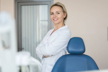 Ofis modern Diş Kliniği, güvenle geçti ve kameraya seyir silah ile ayakta poz güzel kadın dişçi portresi
