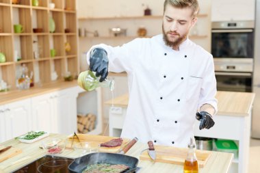 Bel kadar yakışıklı profesyonel şef modern restoran mutfak ayakta ahşap masa ve yemek lezzetli yemekler, kopya alanı çalışma portresi