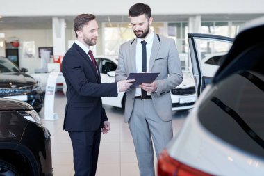 Araba satıcısı bir sözleşme otomatik salonda dururken müşteriye gösterilen