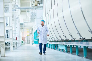 Üst düzey fabrika işçisi kamera geçiş atölye modern tesisi, kopya alanı doğru yürüyüş tam uzunlukta portresi