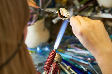 Modern yaratıcı atölye çalışmasında, kopya alanı el yapımı boncuk yaparken Gaz Meşalesi üzerinde cam şekillendirme eller closeup