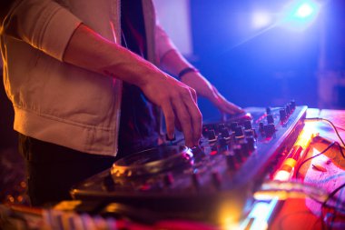 Yan görünümü yakın genç dj müzik moda Kulübü'nde, konsantre ellerde Dg karıştırıcı kadar yanan ışıkları, kopya alanı üzerinde