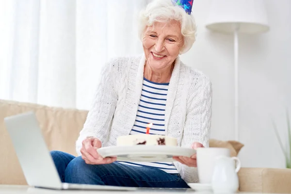 Porträt Einer Glücklichen Seniorin Die Der Kamera Kuchen Zeigt Während — Stockfoto