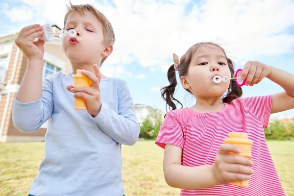 Waist Portrait Two Cute Children Blowing Bubbles While Playing Green — Stock Photo, Image