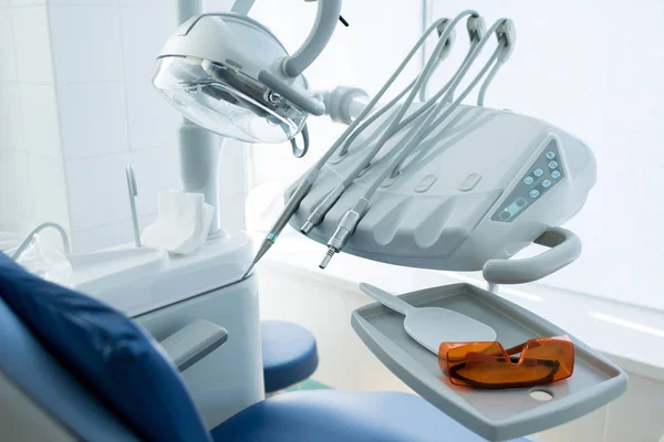 Clean professional design of working machines of dentist placed near client seat.