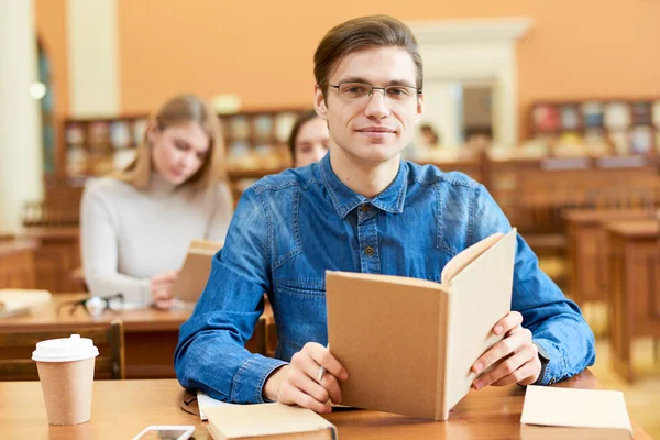 Retrato Agradável Confiante Bonito Jovem Estudante Segurando Livro Aberto Sentado — Fotografia de Stock