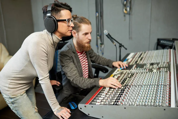 男子和妇女一起在声音工作室的电子板上合作创作音乐 — 图库照片