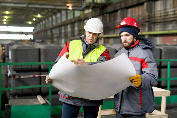 Porträtt Två Ingenjörer Bär Hardhats Hålla Ritningar Och Diskutera Byggandet — Stockfoto