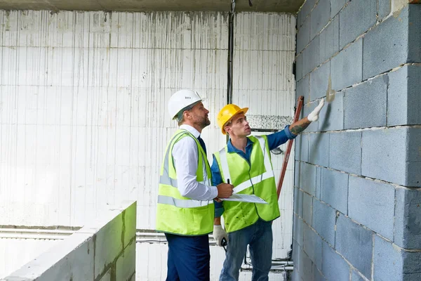 Foreman Felügyelő Megvitatása Befejező Munkálatok Építési Telek Álló Tégla Fal — Stock Fotó