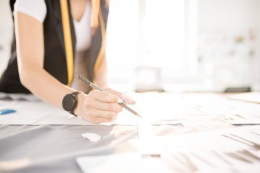 Tanınmayan kadın terzi izleme kumaş dikiş özel süre beyaz tebeşir yapılan giysileri ile closeup