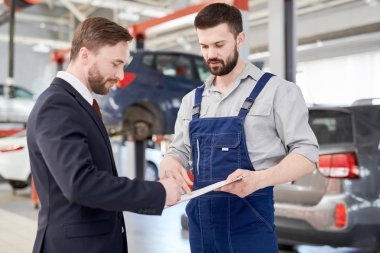 Bel kadar servis garajında modern makinist için konuşurken araba tamir için sözleşme imzalama yakışıklı işadamı portresi