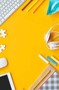 Okul malzemeleri masa genç çocuk, bilgisayar, cetveller ve copybooks üstünde sarı arka plan çerçeveleme Kopyala yer merkezi içinde parlak flatlay bileşimi