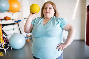 Modern spor salonunda topu tutan büyük kilolu kadın portresi kadar bel