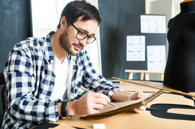 Atelier içinde çalışma ve giyim çizim Not Defteri'nde Eskizler yapım terzi içerik. 