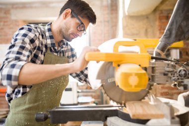 Yan görünümü odaklı modern esnaf talaş ve fırlama woodchips disksaw birim odun parçasının sıkıcı kullanarak portresi
