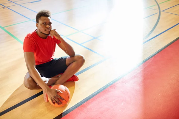 Atractivo Deportista Afroamericano Con Pelota Baloncesto Sentado Suelo Cancha Mirando — Foto de Stock