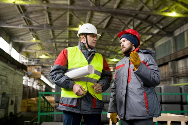 腰上两个工程师穿着安全帽讨论生产在现代工业车间 复制空间 — 图库照片