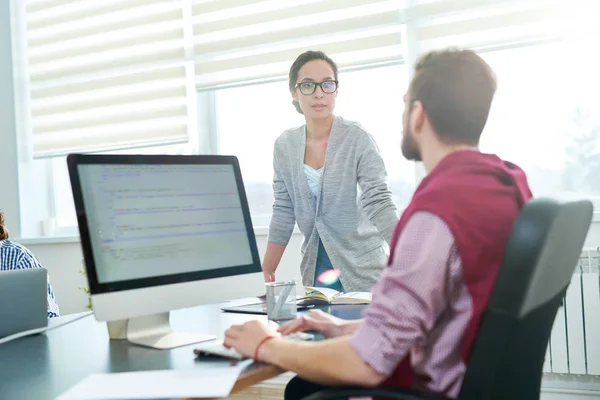 Mujer Joven Discutiendo Trabajo Con Colega Masculino Sentado Mesa Oficina — Foto de Stock