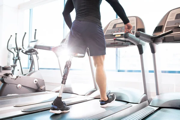 Disabled man training on treadmill in gym