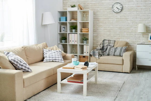 Modernes Wohnzimmer Mit Schlichtem Interieur Uhr Ziegelwand Regale Mit Haushaltspersonal — Stockfoto