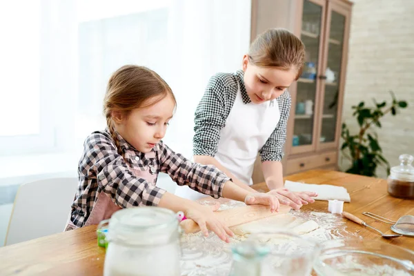 背景に広々 としたキッチンのインテリア母の日 おいしいケーキを作るためには圧延のこね粉のエプロンを身に着けている愛らしい妹 — ストック写真