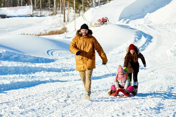 Kaukasiska Man Dra Släde Med Små Barn Längs Snöig Väg — Stockfoto