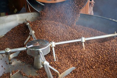 Görünümü arka planını krem kahverengi kahve çekirdekleri yerel esnaf roastery davul makinesinde kavurma için dökülmesini alanı Kopyala