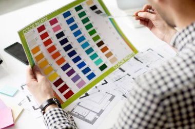 Yakın çekim yaratıcı Tasarımcı renk paleti ofis masası oturma ve yeni iç proje üzerinde düşünme sırasında elinde tutan kadeh