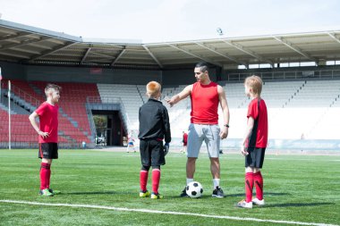 Latin Amerika futbol antrenörü öğretim genç takım çocuklar güneşli açık stadyum, kopya alanı içinde tam uzunlukta portresi
