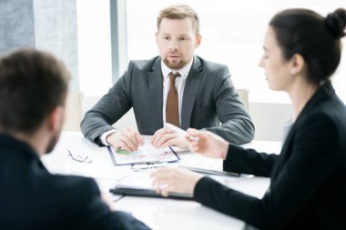 Başlangıç fikirler meslektaşları ile tablo konferans salonunda toplantı otururken açıklayan modern genç işadamı portresi