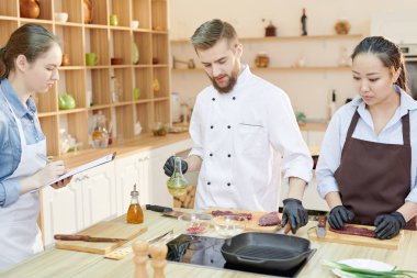 Takım modern restoran mutfak ayakta çalışma profesyonel şefler yuvarlak ahşap masa ve yemek lezzetli yemekleri birlikte, uzay kopyalayın