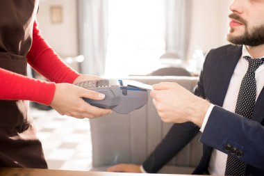 Öğle yemeği için ödeme ve kredi kartı kart okuyucuya Restoran, garson ödemeyi terminal içeren nfc kullanırken koyarak elbiseli sakallı işadamı Close-up