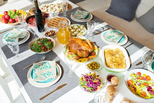 High angle view of festive dinner table set for whole family with delicious  turkey and homemade dishes, served with robin blue plates and napkins, copy space background
