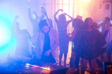 İnsanlar gece kulübünde yakışıklı genç Dj ayakta, müzik, kopya alanı yapma karıştırıcı ile dans kalabalık
