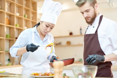 Bel odaklı kadın Asya Şef su-chef, kopya alanı ile modern restoran mutfakta çalışırken lezzetli yemekleri pişirme portre kadar